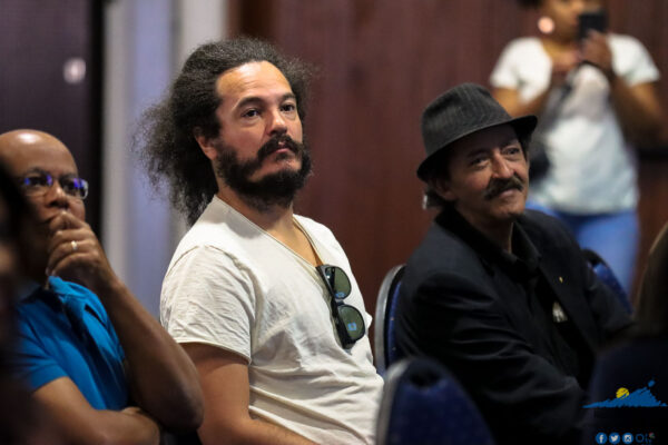 Deux hommes assis et écoutant attentivement lors d'une conférence.