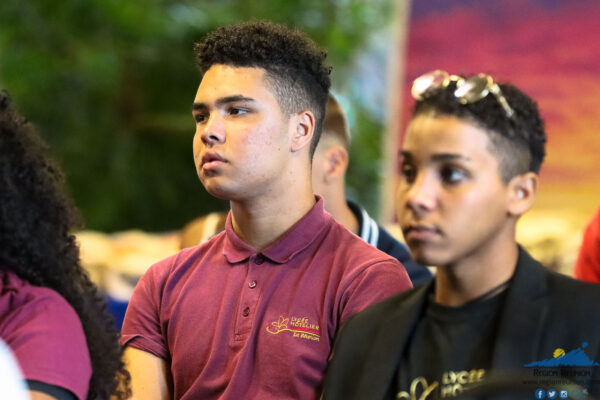 Deux jeunes hommes concentrés lors d'une conférence.