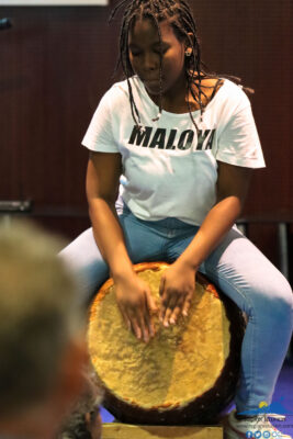 Une jeune fille jouant du rouler lors d'une performance de Maloya
