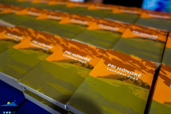 Une pile de livrets marqués "Pri Honoré LanKrÉol 2022" disposés sur une table.