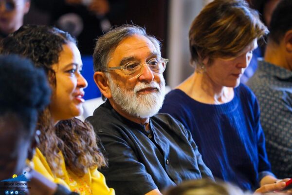 Un groupe de personnes assises dans le public, dont Gora PATEl.