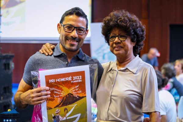Un homme tenant une affiche du Pri Honoré 2022 pose avec une femme, probablement un membre du jury.