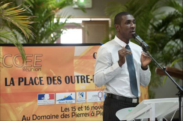 Un intervenant en costume et cravate s’exprimant au micro lors du colloque inter-CCEE 2010.