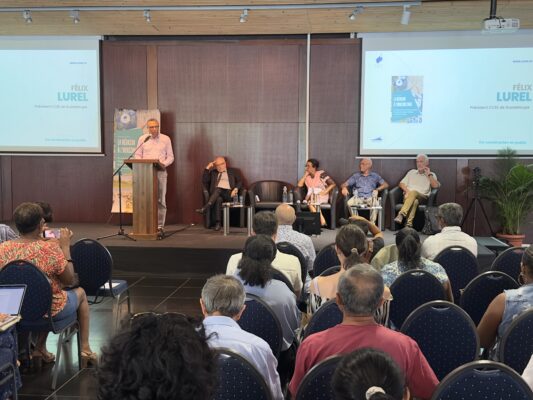 Félix Lurel, président du CCEE de Guadeloupe, s'exprime. Des membres du panel sont assis à sa droite sur une scène. Le public est attentif."