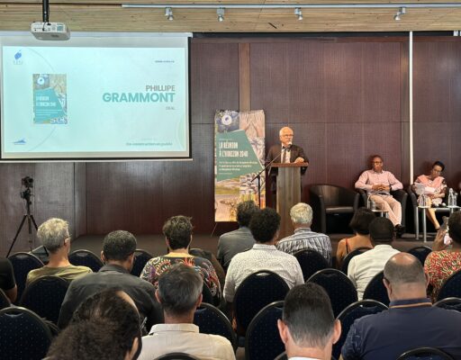 Philippe Grammont du DEAL parle lors d'une conférence sur 'La Réunion à l'horizon 2040', devant un public. Le panel est assis à droite, et une bannière mentionne l'adaptation au changement climatique