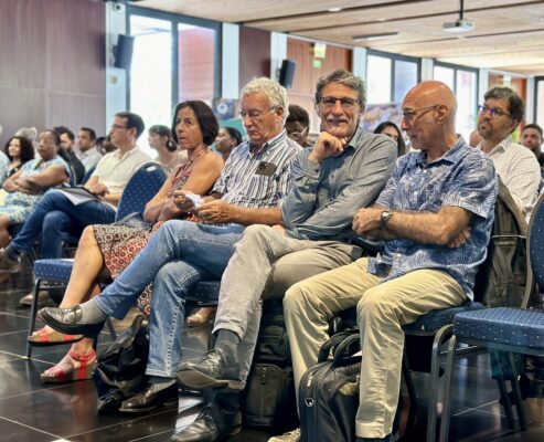 Des membres du CCEE, assis dans une salle de conférence, écoutant les présentations. Certains sourient et discutent entre eux, tandis que d'autres consultent des documents