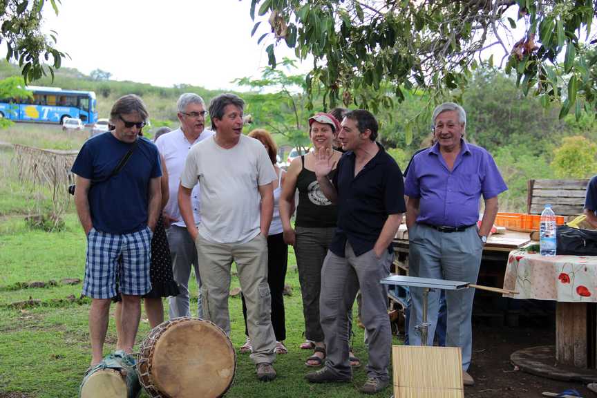 Groupe de participants rassemblés en extérieur autour d’instruments de musique traditionnels.