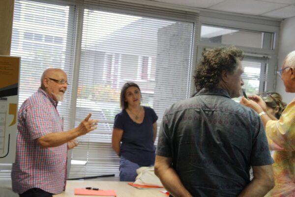 Échange entre plusieurs membres du CCEE debout près d’une fenêtre lors d’une réunion.