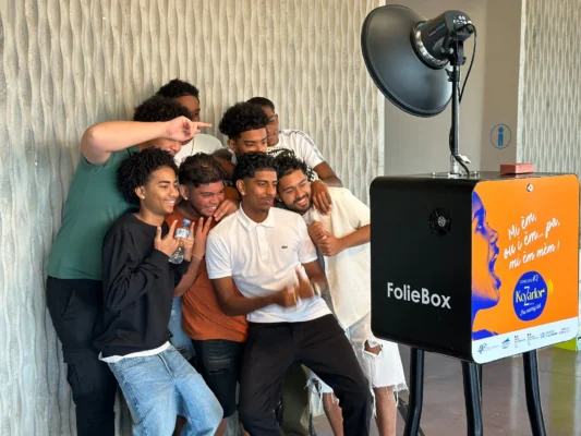Groupe de jeunes prenant une photo avec la cabine photo FolieBox.