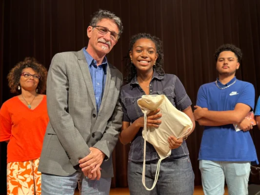 Wassilat Aboudou tenant son prix aux côtés de Gille Lajoie, qui l'accompagne sur scène