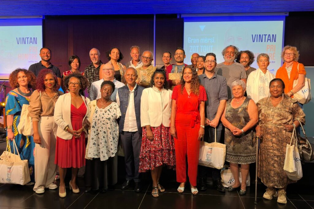 Groupe de lauréats et officiels posant lors de la cérémonie du Vintan Pri Honoré 2024.