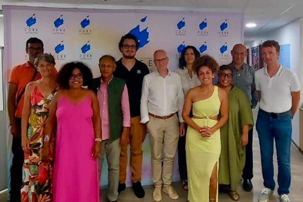 Groupe de participants posant devant une affiche du CCEE lors d'une rencontre avec Hervé Godechot, membre de l'Arcom France, à propos des médias et usages numériques. ​