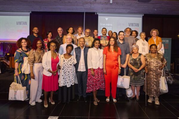 Grande photo de groupe réunissant les participants, les officiels et les organisateurs sur scène lors de la remise des prix Vintan Pri Honoré 2024. Plusieurs personnes tiennent des sacs aux couleurs du CCEE.