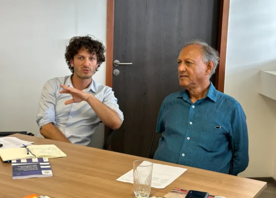 Deux membres du CESE et du CCEE en pleine discussion lors d’une réunion de travail, documents et notes sur la table.
