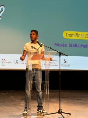 Candidat 01 s’exprimant au micro lors de la demi-finale Kozarlor 2025 au Musée Stella Matutina