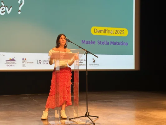 Candidat 13 s’exprimant au micro lors de la demi-finale Kozarlor 2025 au Musée Stella Matutina