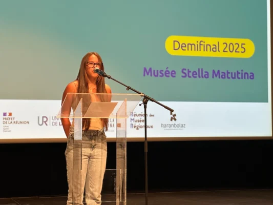 Candidat 16 s’exprimant au micro lors de la demi-finale Kozarlor 2025 au Musée Stella Matutina