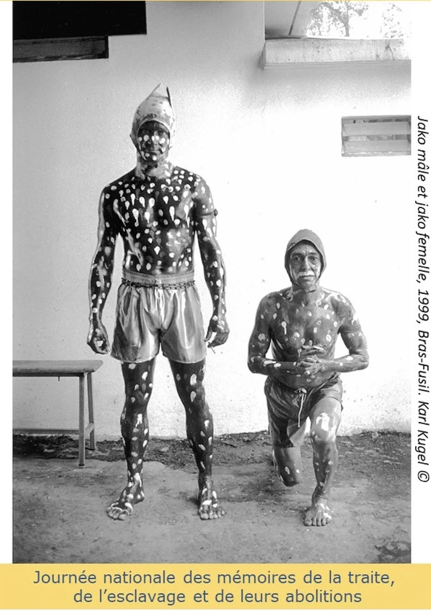 Photographie en noir et blanc de deux personnes peintes de motifs blancs, intitulée 'Jako mâle et jako femelle', réalisée à Bras-Fusil en 1999 par Karl Kugel