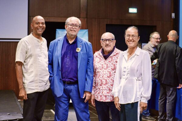 Portrait de quatre invités officiels souriants lors d’un événement sur la diversité culturelle, posant côte à côte