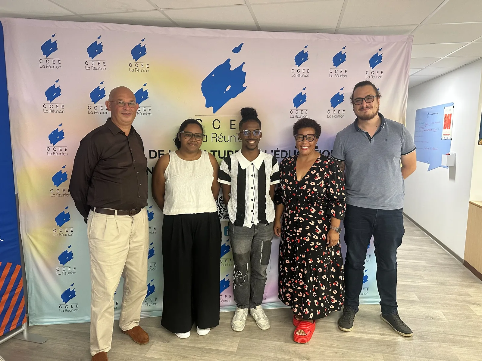 Groupe de cinq personnes posant devant un kakémono du CCEE La Réunion.