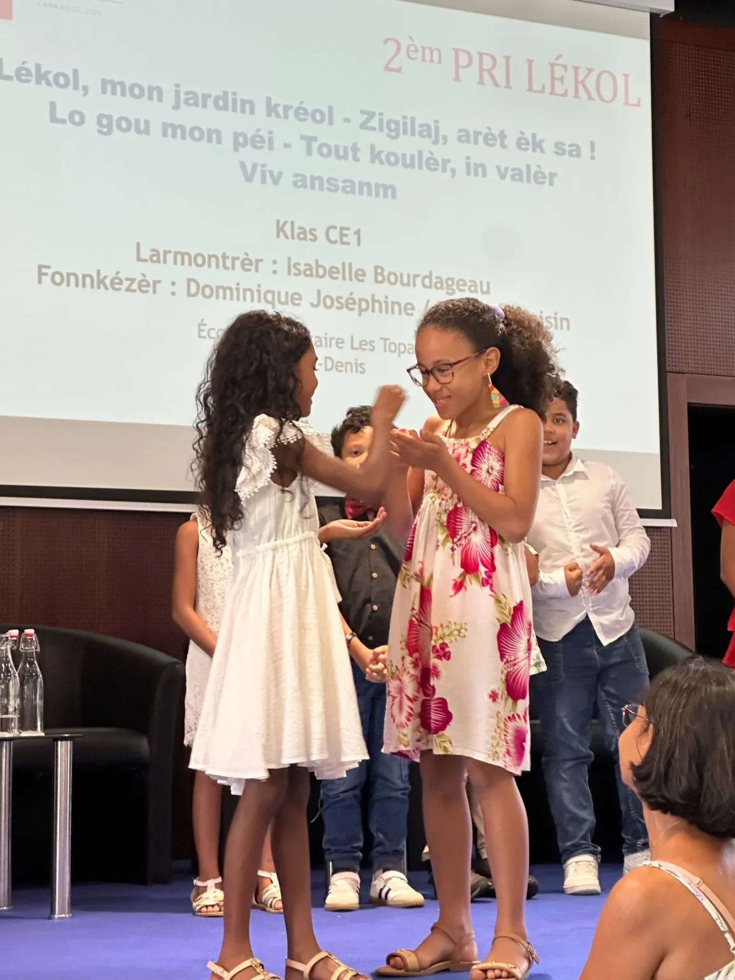 Deux élèves de CE1 de l'école Les Topazes de Saint-Denis sur scène au MoCA, célébrant leur 2ème Prix Lékol lors de la remise des prix du Pri Honoré pou lékol 2026