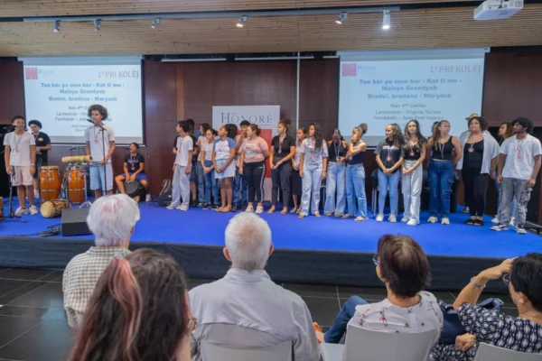 Des collégiens se tiennent sur scène lors de la remise du premier prix Pri Kolèj du Pri Honoré pou lékol 2026, devant le public